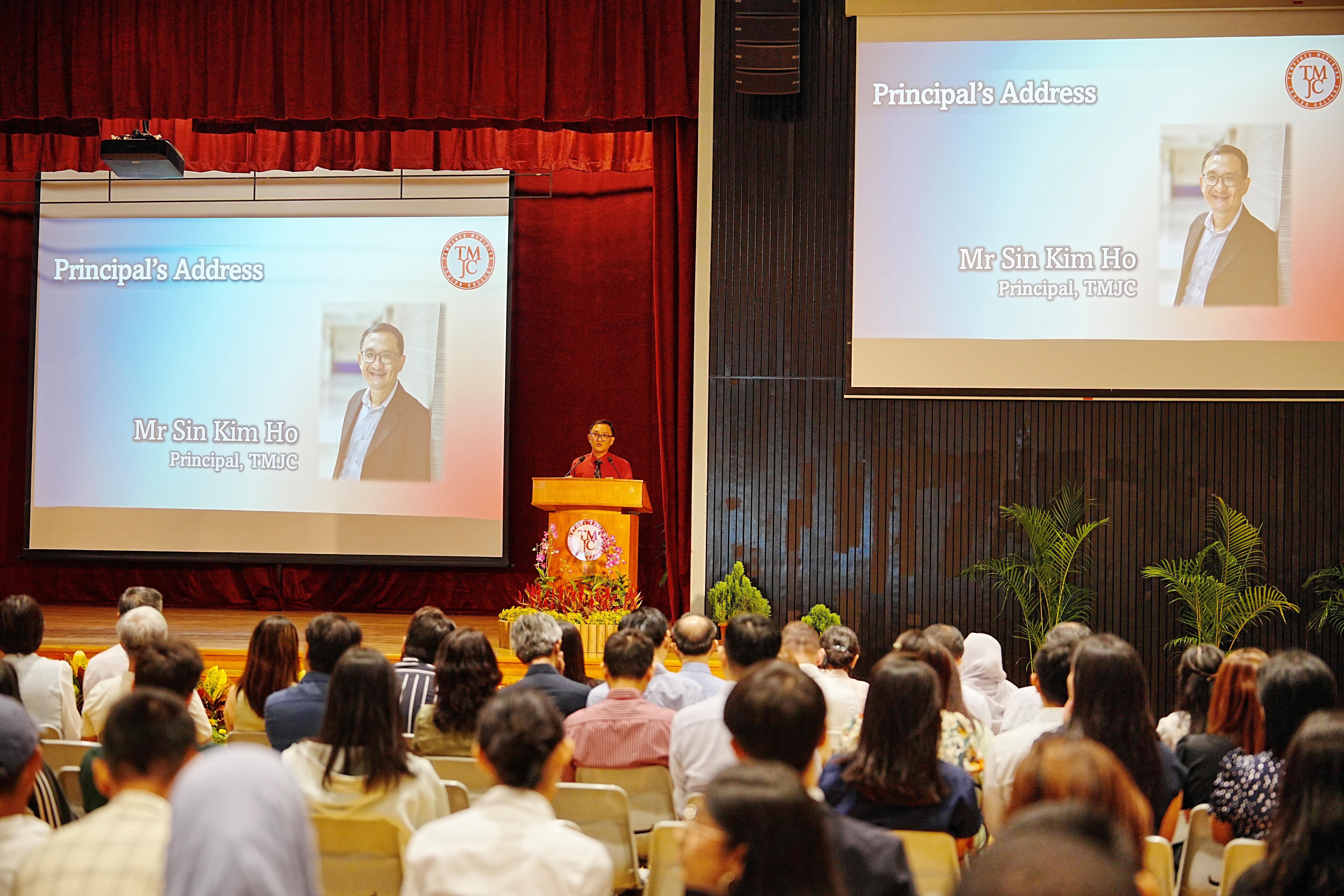 TMJC Principal Mr Sin Kim Ho delivering his address at a podium before a large seated audience